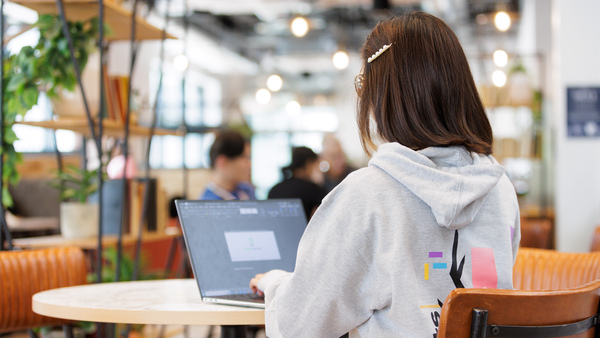 Student on a laptop sat in a cafe area
